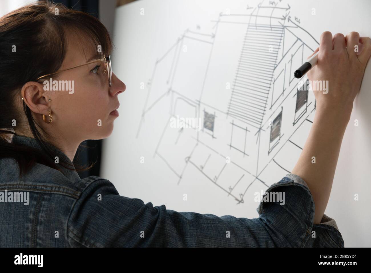 Primo piano di una giovane architetto femminile disegnando un disegno per un nuovo progetto famaly home. Concetto di lavoro su disegni tecnici Foto Stock
