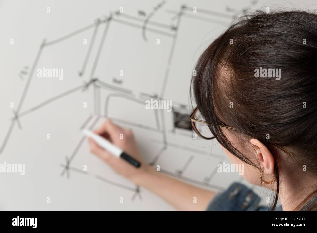 Primo piano di una giovane architetto femminile disegnando un disegno per un nuovo progetto famaly home. Concetto di lavoro su disegni tecnici Foto Stock