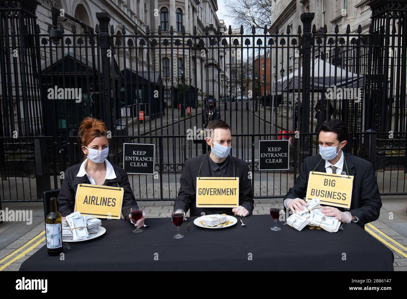 I manifestanti di un gruppo chiamato "Pause the System" indossano maschere facciali durante la dimostrazione al di fuori di Downing Street a Londra. Il gruppo chiede al governo una maggiore azione in quanto il numero dei morti di coronavirus nel Regno Unito ha raggiunto le 144 alle 13.00 di giovedì, con circa quattro su 10 di tutte le morti finora a Londra. Foto Stock
