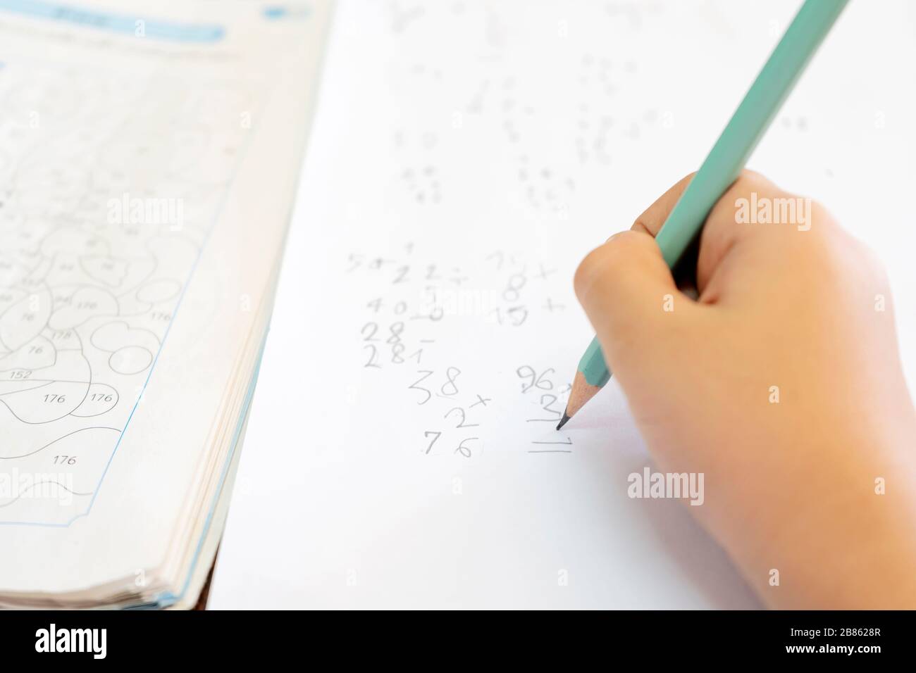 I bambini stanno pensando di risolvere i problemi matematici. Nel livello di difficoltà della scuola elementare, utilizzare la matita per lavorare e fare un test sul lato. Foto Stock