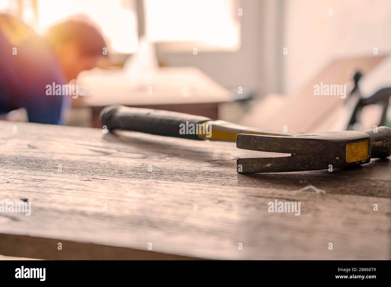 Carpentiere costruire una casa e lavorare con martello e legno. Il martello è un oggetto della scena anteriore. Foto Stock