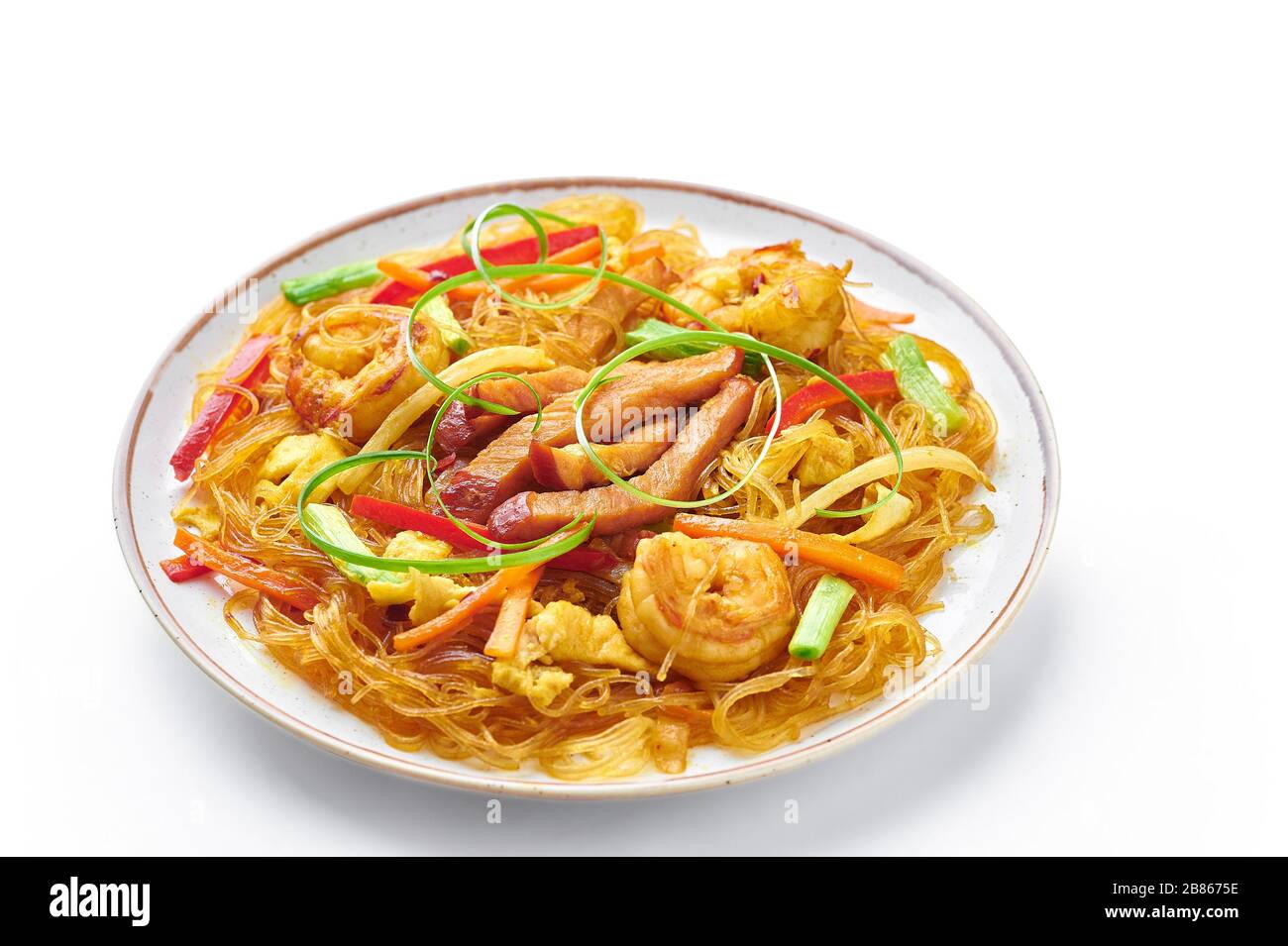 Singapore Mei Fun in piatto isolato su sfondo bianco. Singapore Noodles è un piatto di cucina cinese con tagliatelle di riso, gamberi, maiale char siu, carota, r Foto Stock
