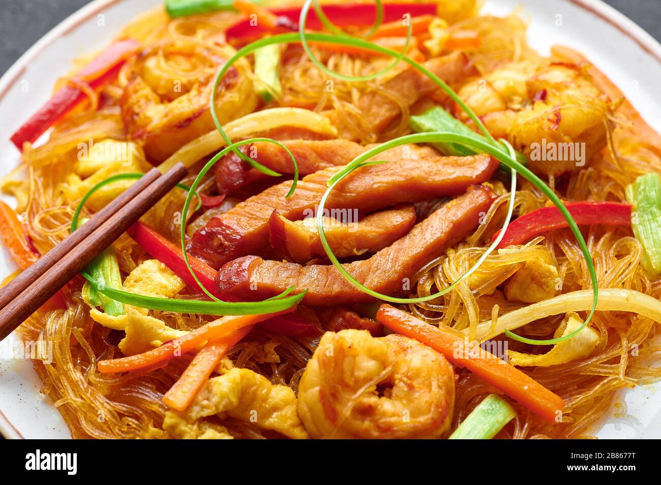 Singapore Mei Fun. Singapore Noodles è un piatto di cucina cinese con tagliatelle di riso, gamberi, maiale char siu, carota, cipolla rossa, cavolo di nappa. Cibo cinese. Foto Stock