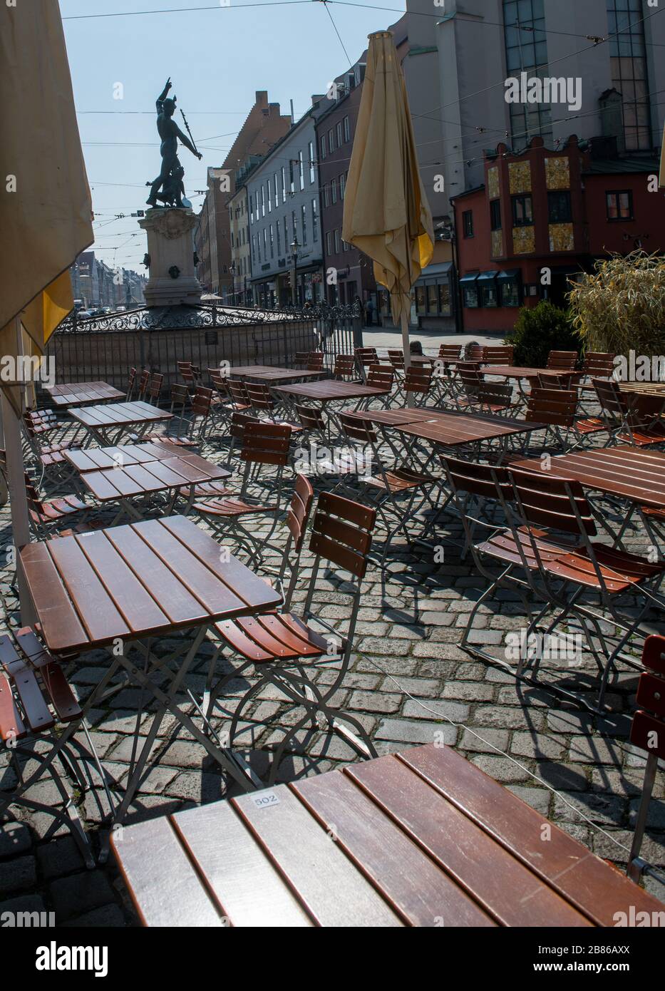 Augusta, Germania. 20 Marzo 2020. Di fronte al Merkurbrunnen su Maximilianstraße, i tavoli e le sedie di un bar di strada sono deserte la mattina tardi. Credit: Stefan Puchner/dpa/Alamy Live News Foto Stock
