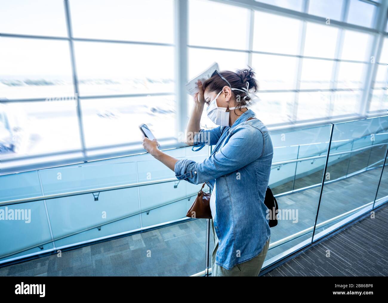 Restrizioni di viaggio per l'epidemia di coronavirus. Viaggiatori con maschera facciale all'aeroporto internazionale interessati da cancellazioni di voli e divieto di viaggio. COVID-19 Foto Stock