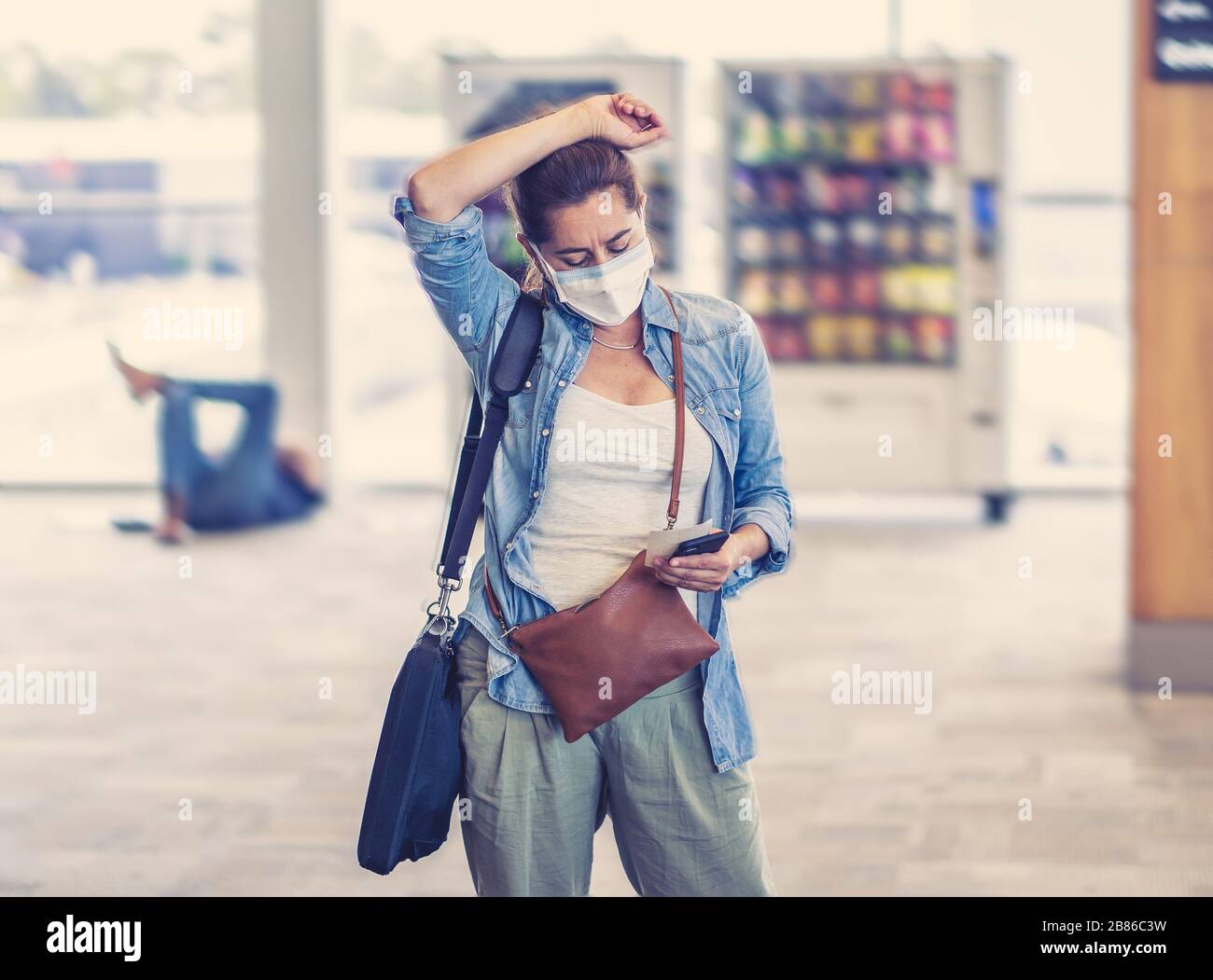 Restrizioni di viaggio per l'epidemia di coronavirus. Viaggiatori con maschera facciale all'aeroporto internazionale interessati da cancellazioni di voli e divieto di viaggio. COVID-19 Foto Stock