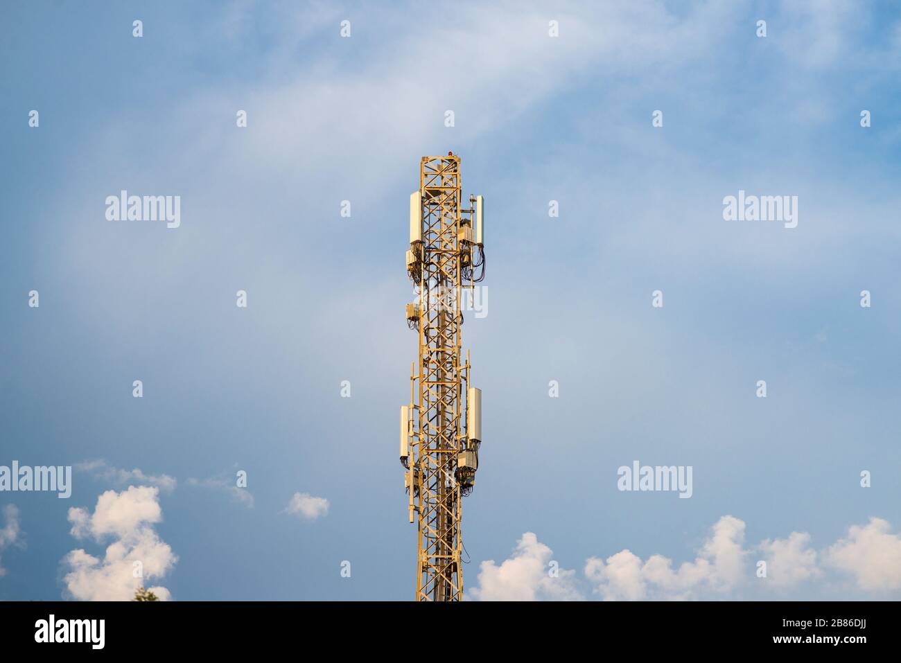 Struttura in metallo elevato con stazione base per antenna di rete cellulare per telefoni cellulari. Torre di telecomunicazione con antenne che trasmettono e irradiano alta P Foto Stock