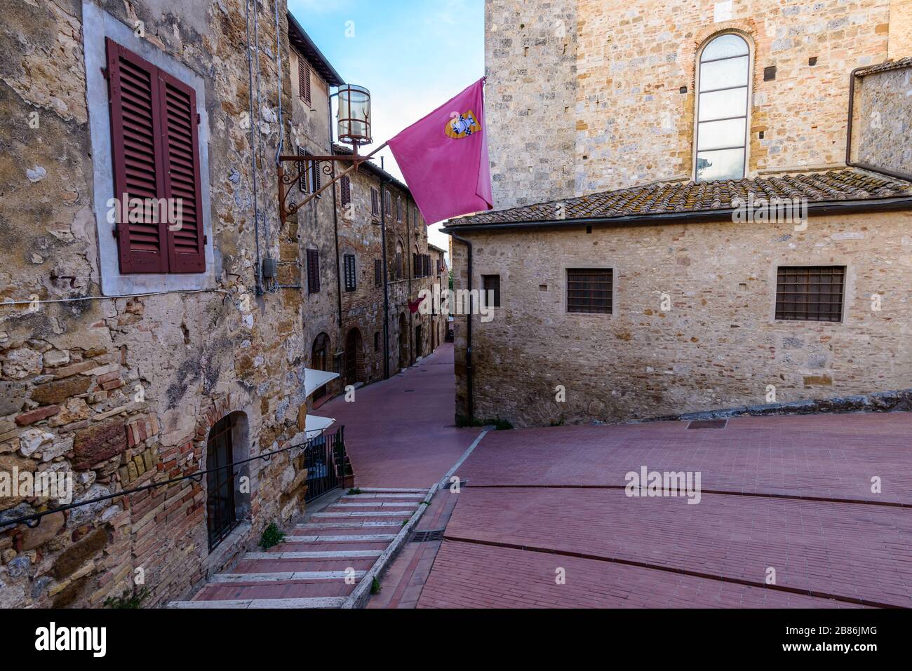 San Gimignano, Toscana: Guardando in fondo una stradina verso Piazza delle Erbe da Via della Rocca in serata. Foto Stock