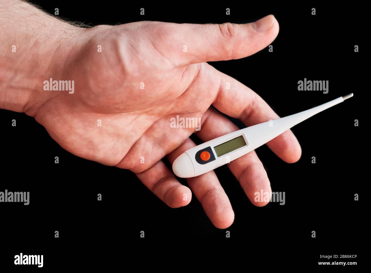 Termometro elettronico in una mano maschile forte su sfondo nero. Fermata Coronavirus. 2019 romanzo Coronavirus (2019-nCoV). Contenuto medico Foto Stock