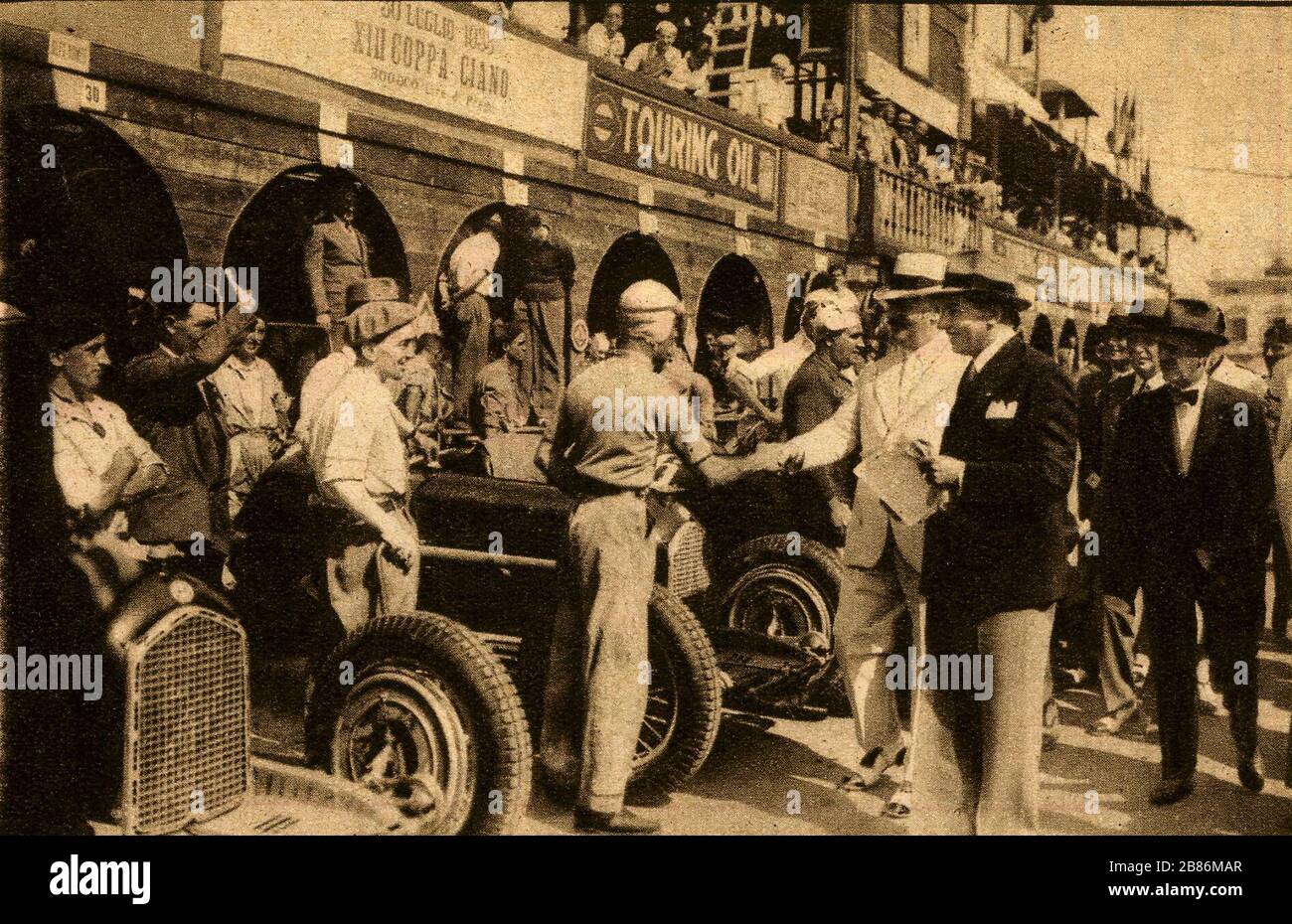 L'inglese: S. E. Costanza Ciano scuote le mani con driver Maserati Tazio  Nuvolari al XIII Coppa Ciano sulla luglio 30, 1933. Il banner dice 30  luglio 1933 XIII Coppa Ciano. Nella parte