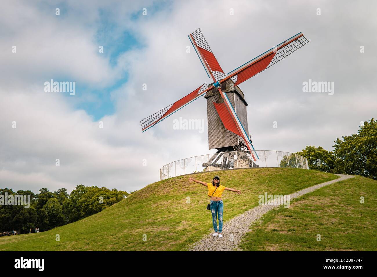 Brugge Belgium, casa colorata nella città vecchia di Brugge , giovane donna libera in città dal vecchio mulino a vento, Bruges, Belgio. Vento di Sint Janshuismolen Foto Stock