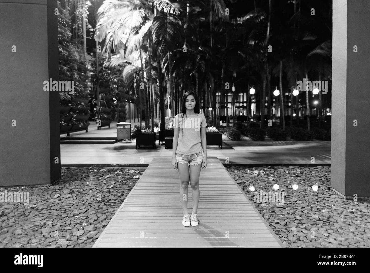 Giovane bella donna asiatica in piedi sul lungomare di legno dell'ingresso dell'hotel Foto Stock