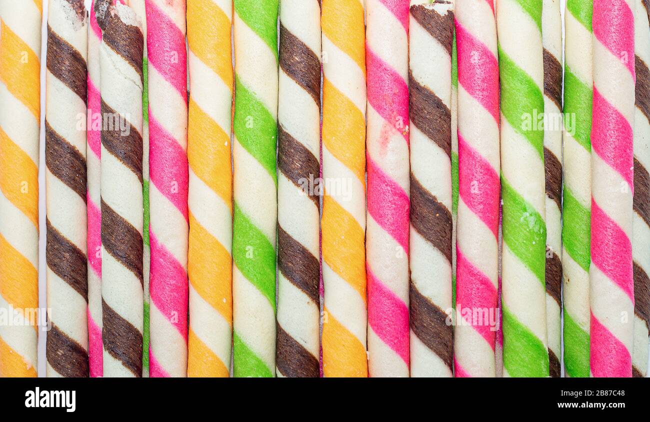 rotolo di snack croccante arcobaleno con sapore misto su sfondo bianco Foto Stock