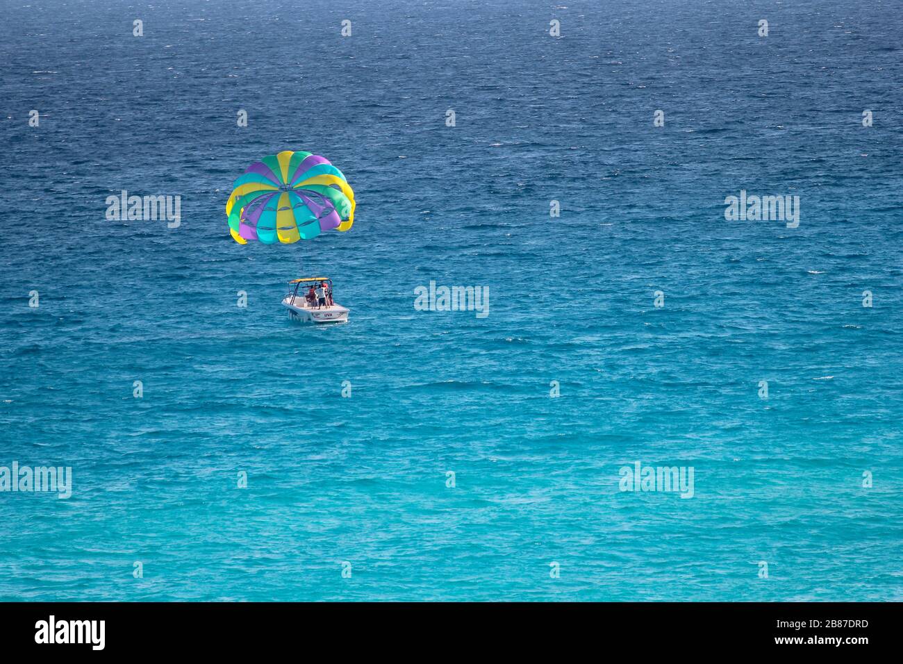 Parasailing barca sulle acque di una spiaggia nella zona Hotel, Cancun, Quintana Roo, Yucatan Peninsula, Messico Foto Stock