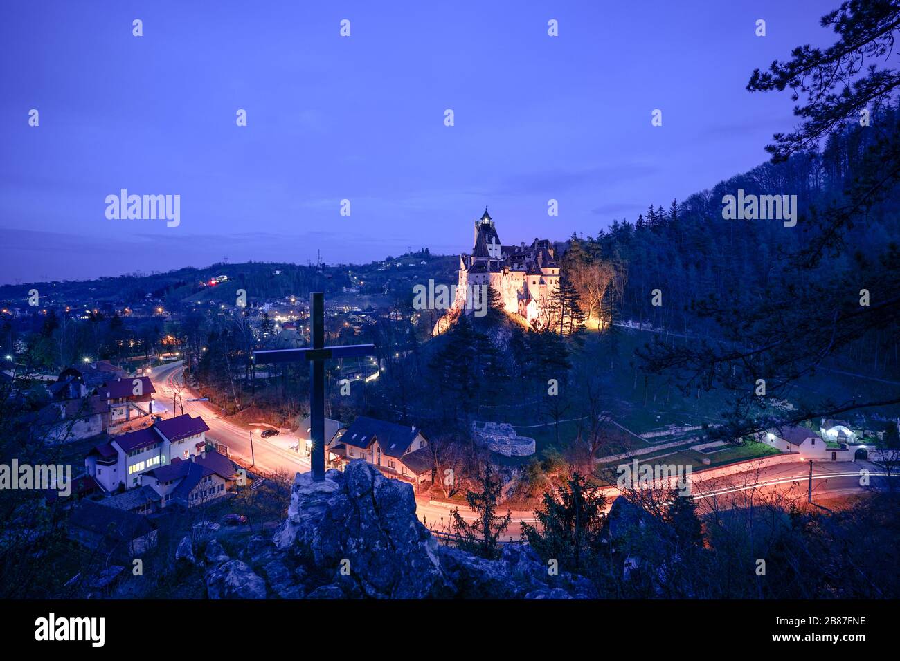 Il castello di Dracula situato a Bran, Transilvania, Romania di notte con una croce in primo piano Foto Stock