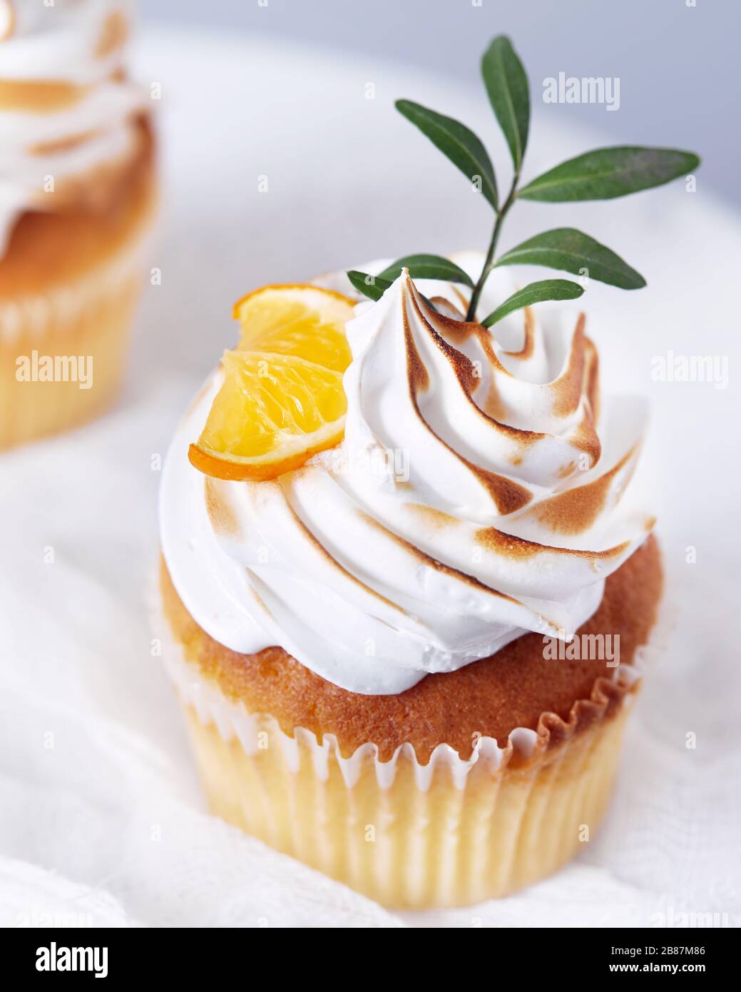 Cupcake fatti in casa decorati con limone e foglie su sfondo bianco Foto Stock