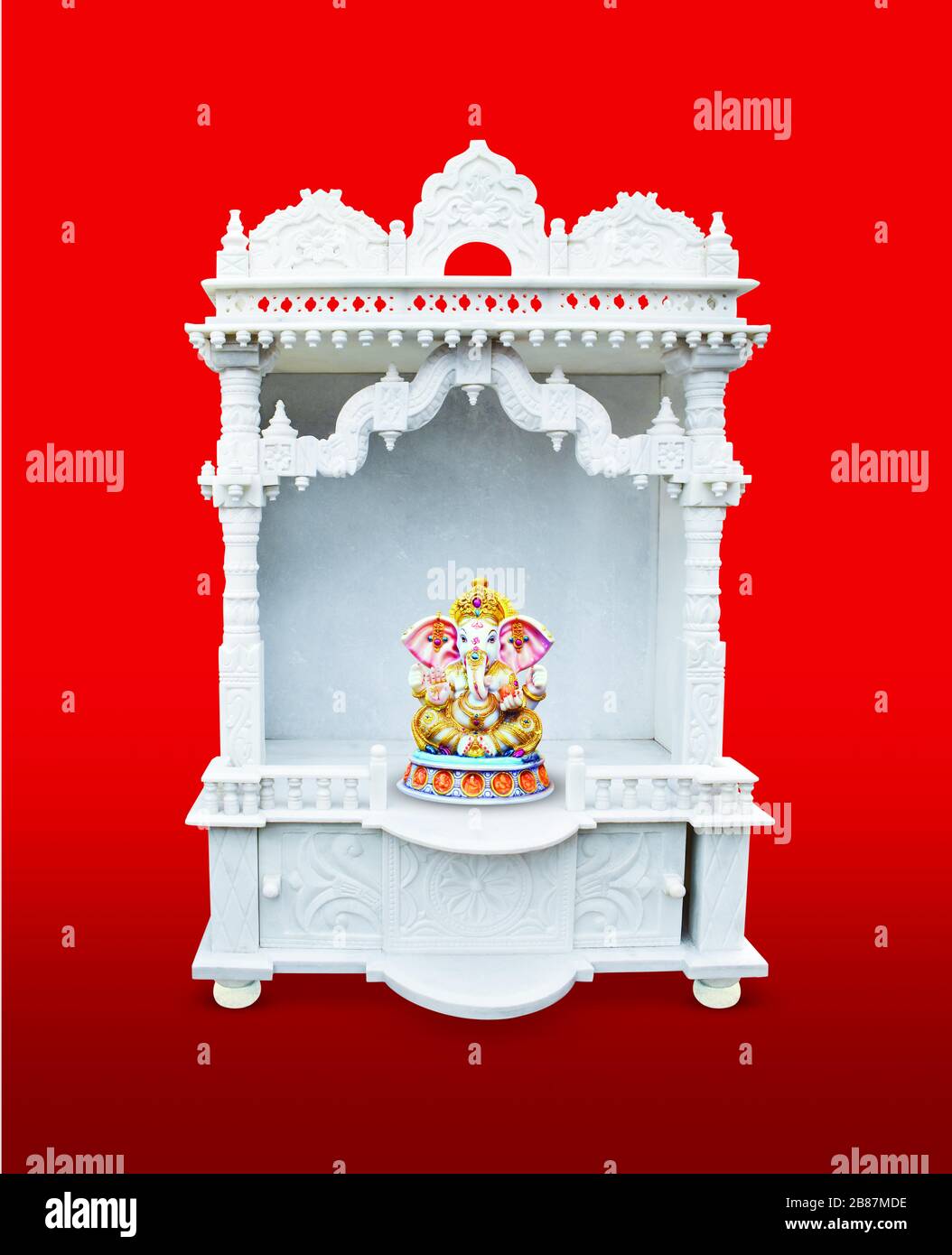 Pavimento in marmo bianco Tempio per la stanza di Puja con Ganesh Idol su sfondo rosso - isolato Foto Stock