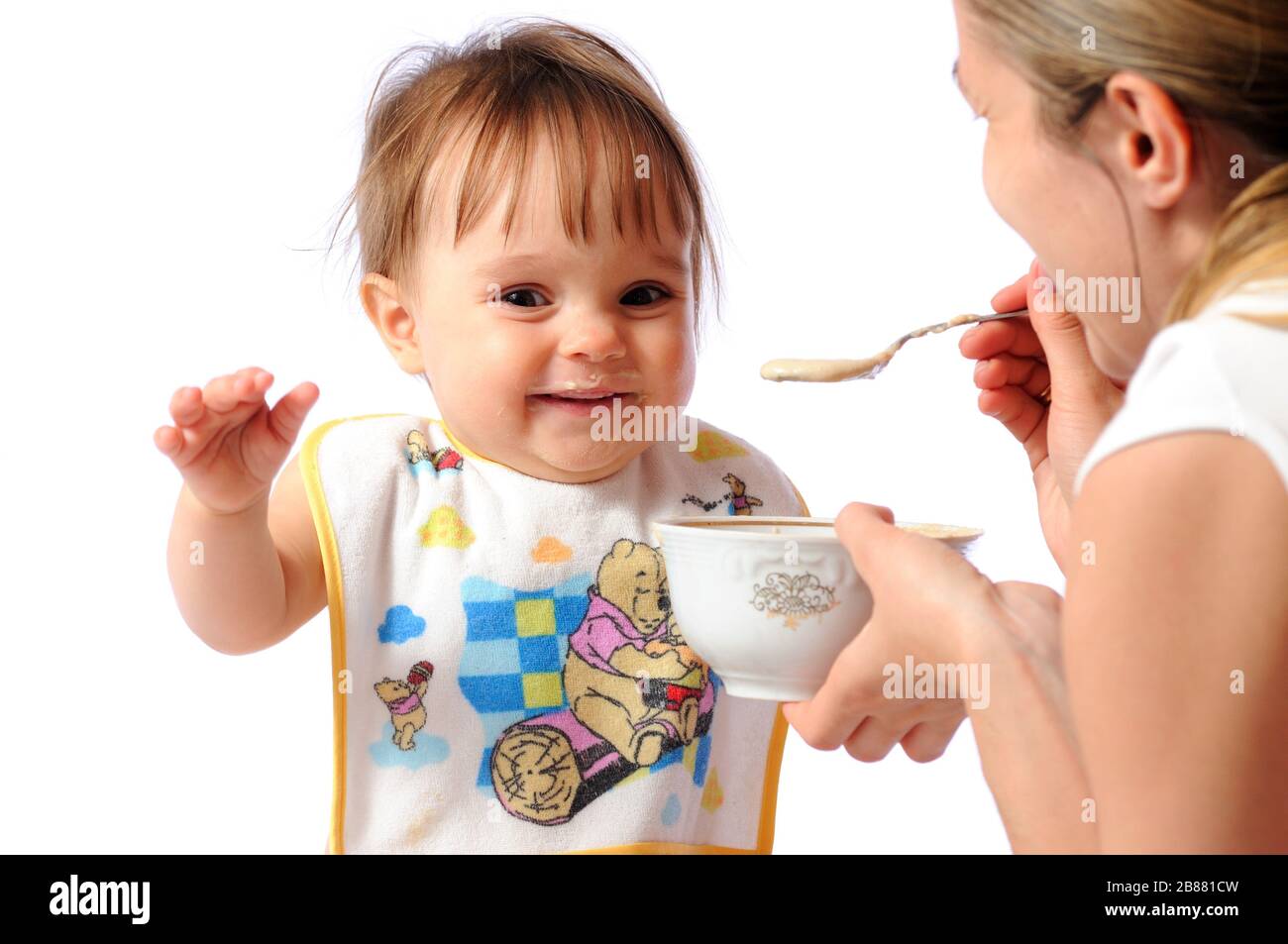 La Madre Alimenta La Bambina Di Un Anno Di Cibo Per Bambini O Porridge Con Cucchiaio Il Bambino Mangia Sfondo Chiaro Foto Stock Alamy