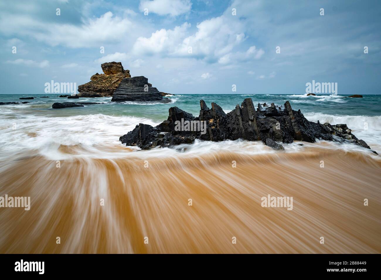 L'acqua che scorre dietro forma un bel modello sulla spiaggia di sabbia; costa atlantica; Algarve; Portogallo Foto Stock