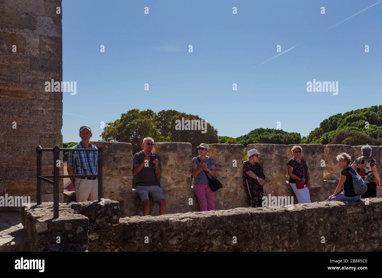 Anziani turisti europei seduti sui bastioni del Castello di São Jorge. Foto Stock