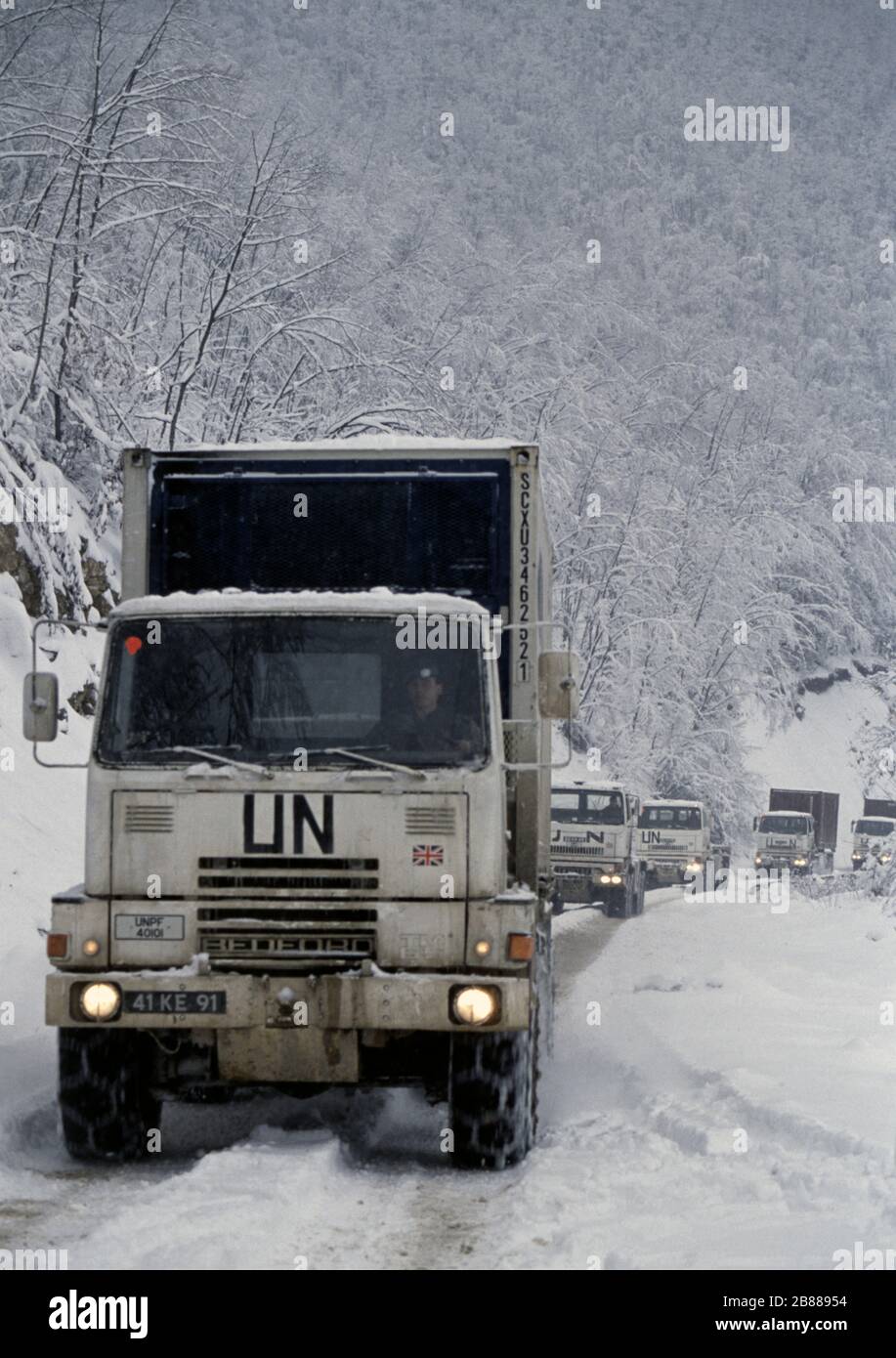 21 gennaio 1994 durante la guerra nella Bosnia centrale: Un convoglio di camion dell'esercito britannico guida a nord attraverso la neve pesante, lungo la Route Diamond, appena a nord di Gornji Vakuf. Foto Stock