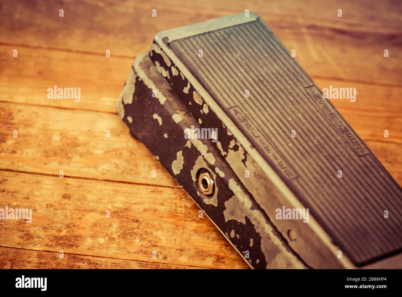 Guitar Wah Wah Pedal su un pavimento di legno duro sporco. Foto Stock
