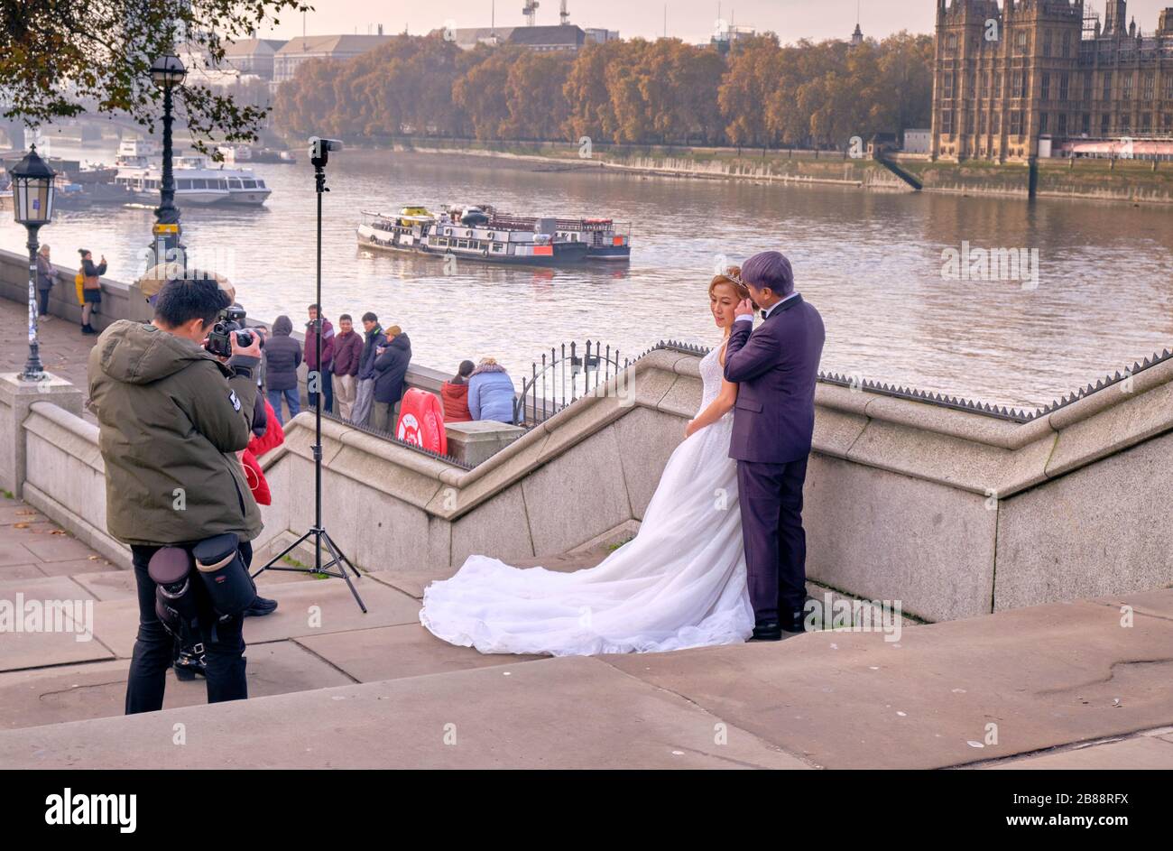 Fotografo di matrimonio che fotografa la coppia lungo il Tamigi a Londra Foto Stock