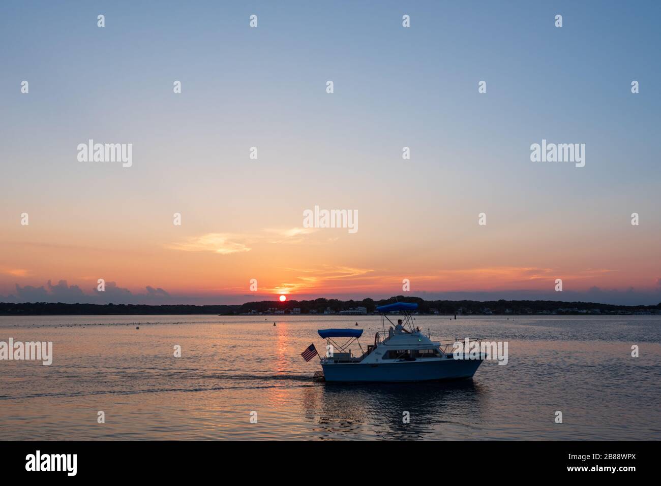 Belmar, NJ, USA -- 19 luglio 2017. Una piccola barca naviga nel fiume Shark al tramonto in una giornata estiva a Belmar, NJ Foto Stock