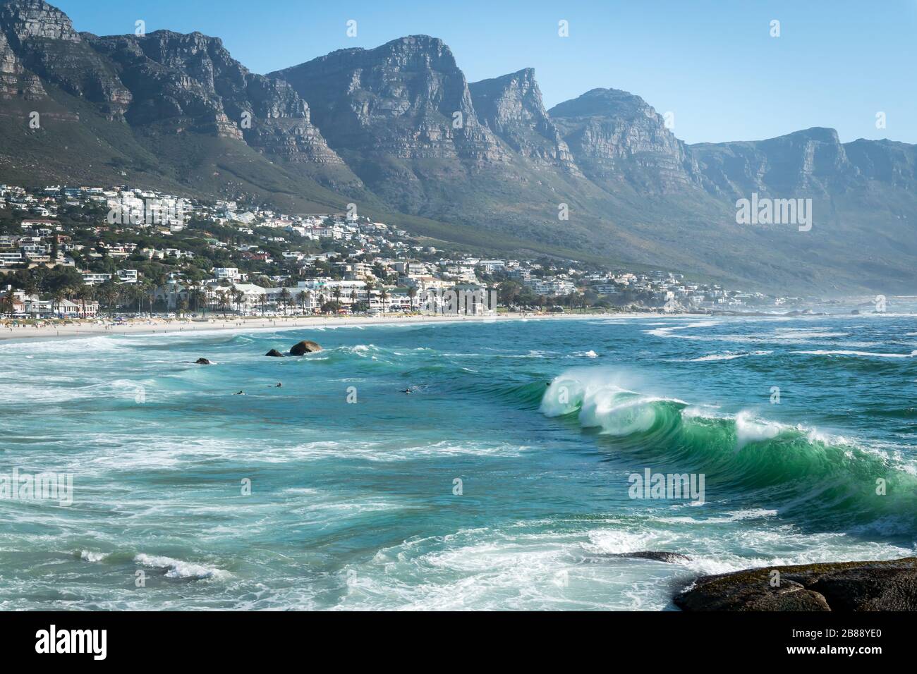 Città del Capo, Sud Africa - 25 novembre 2019 - onde nell'oceano Atlantico su Camps Bay Beach e catena montuosa dei dodici Apostoli Foto Stock
