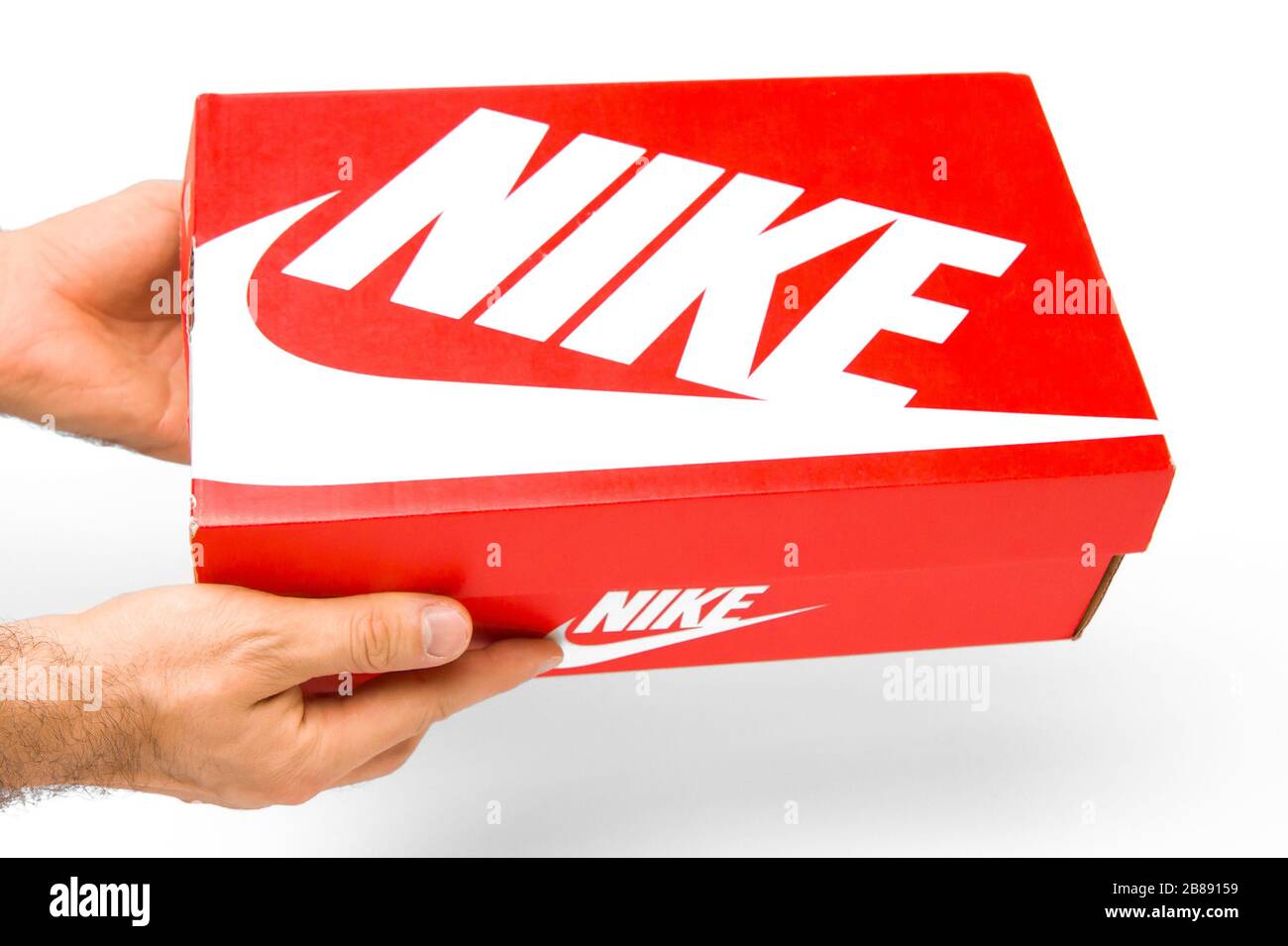 Vista frontale su Nike Box di mans su sfondo bianco. Primo piano mani mans  in possesso di una scatola rossa per le scarpe, San Francisco, USA, marzo  2020 Foto stock - Alamy