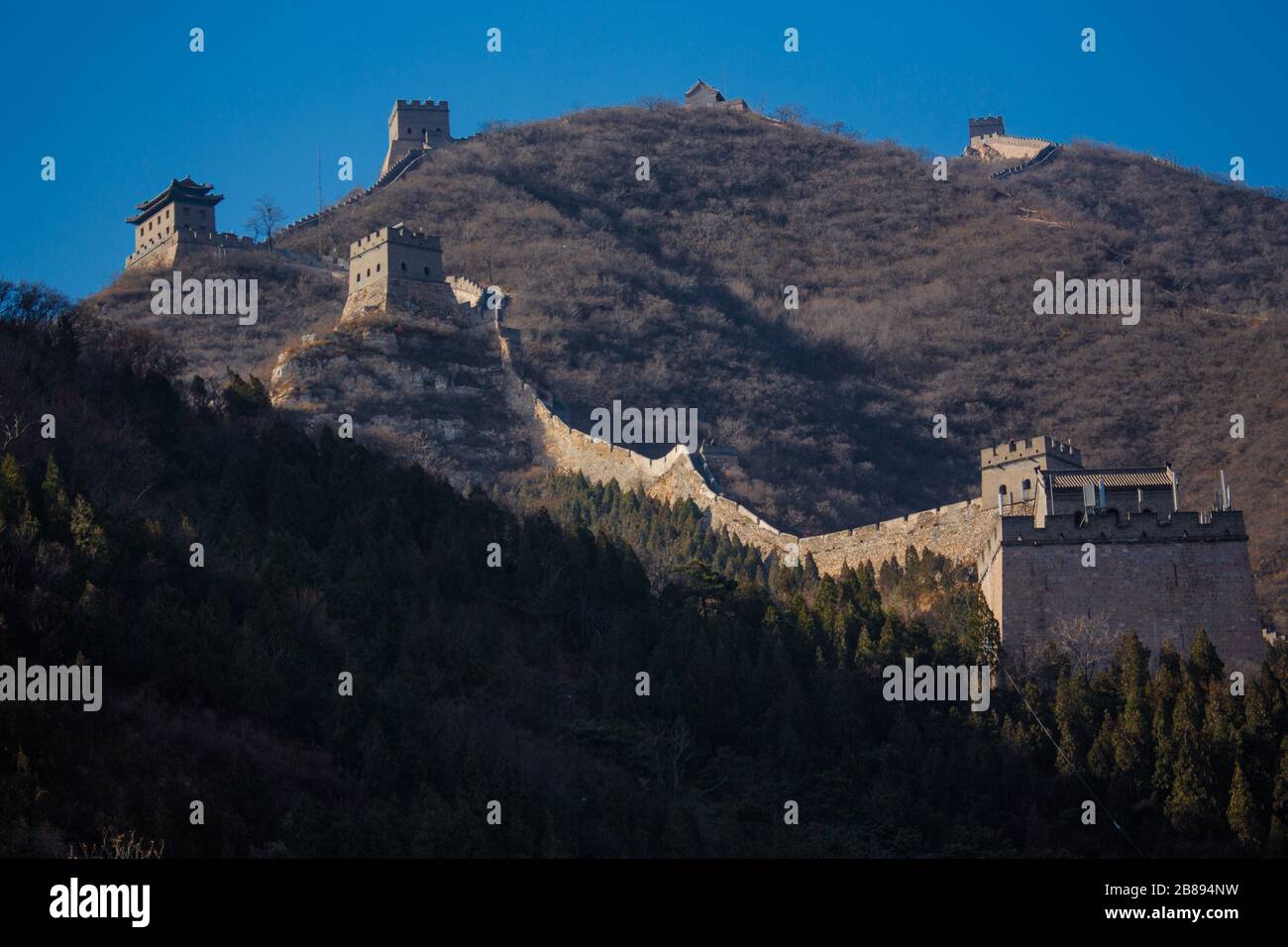 Il sole si fissa in una giornata di cielo blu alla Grande Muraglia Cinese, Pechino, Cina Foto Stock