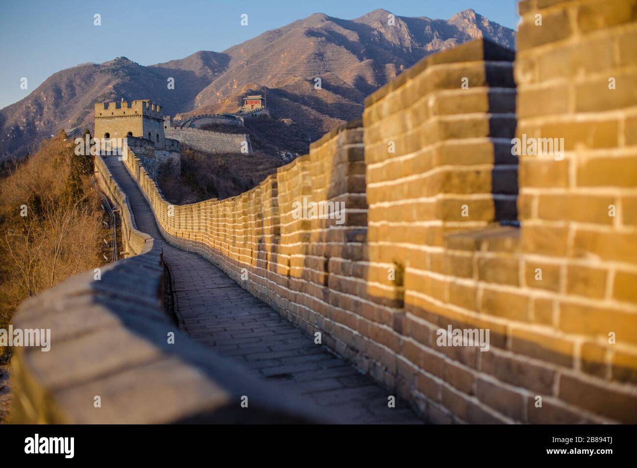 Il sole si fissa in una giornata di cielo blu alla Grande Muraglia Cinese, Pechino, Cina Foto Stock
