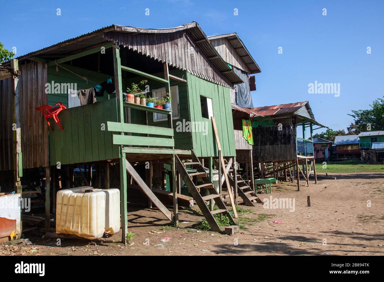 Casa palafitte indiana sull'argine del fiume Amazzonia, sull'altro lato del porto di Leticia Colombia in Perù, Sud America. Foto Stock