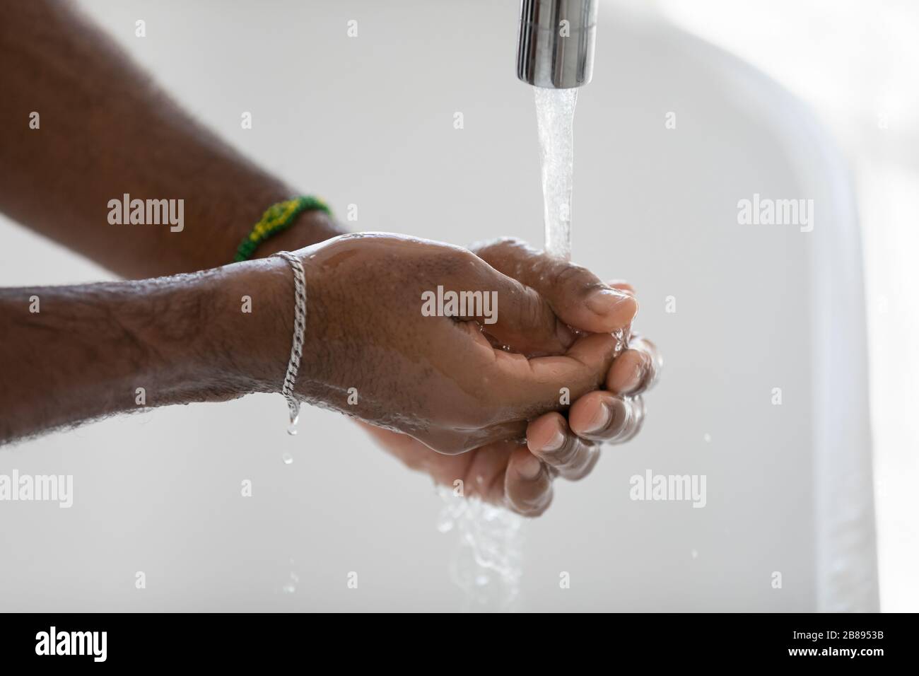 L'uomo africano lavando le mani sotto l'immagine di closeup dell'acqua corrente Foto Stock