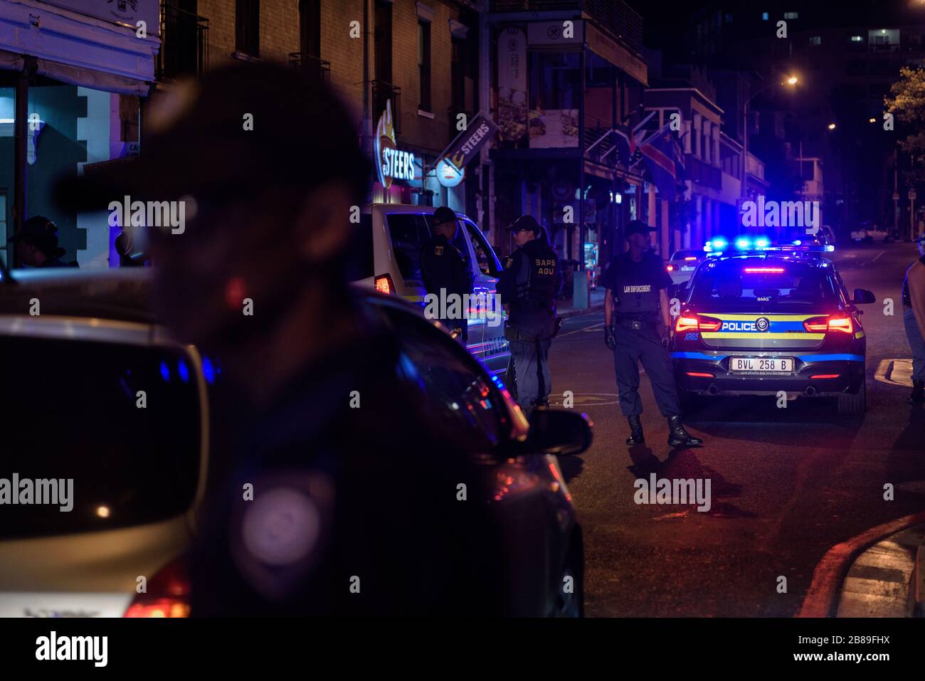 Il Sud Africa ha un coprifuoco delle 18:00 per bar e club per contenere la diffusione del Coronavirus. Polizia che attua l'ordine a Long Street di Città del Capo Foto Stock