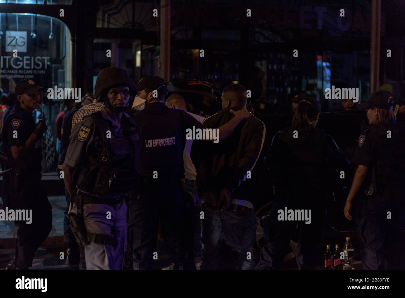 Le forze di sicurezza detengono sospetti durante un'operazione nel quartiere della vita notturna di Città del Capo di Long Street in Sud Africa nell'era pandemica del coronavirus Foto Stock