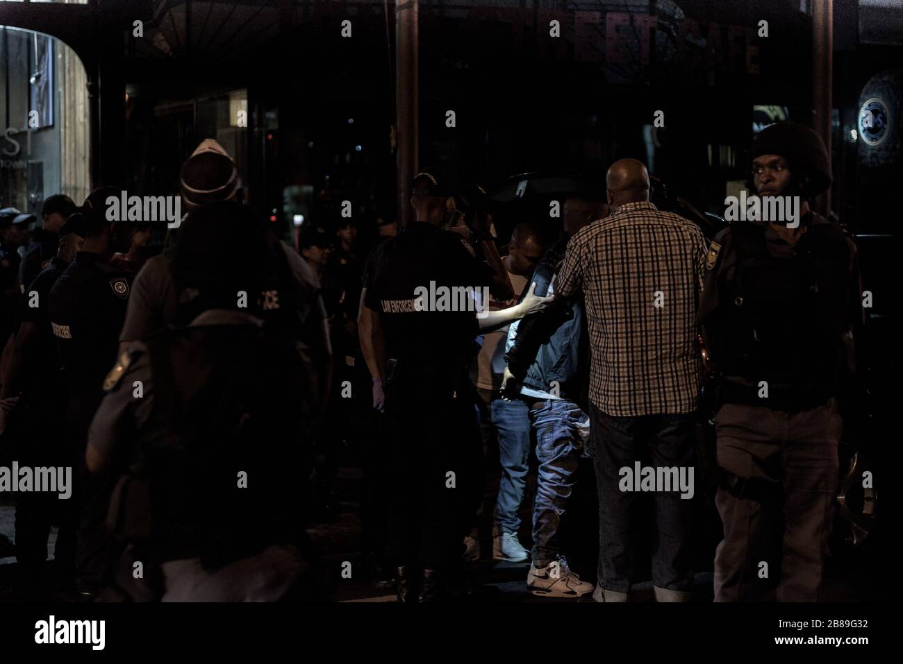 Le forze di sicurezza detengono sospetti durante un'operazione nel quartiere della vita notturna di Città del Capo di Long Street in Sud Africa nell'era pandemica del coronavirus Foto Stock
