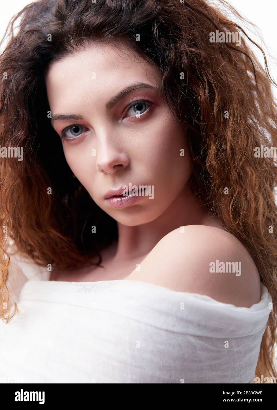 Ritratto ravvicinato della giovane donna seria con capelli ricci Foto Stock