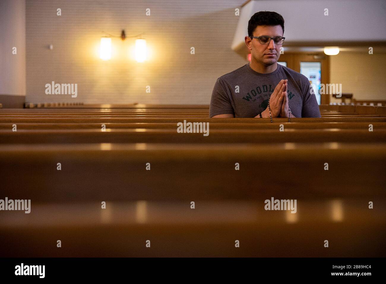 Sacramento, CA, Stati Uniti. 20 Marzo 2020. Joshua Figueroa si inginocchia nella parrocchia di Sant'Ignazio Loyola per la preghiera e la meditazione tranquilla durante lo scoppio della pandemia di coronavirus venerdì 20 marzo 2020 a Sacramento. Credit: Paul Kitagaki Jr./ZUMA Wire/Alamy Live News Foto Stock