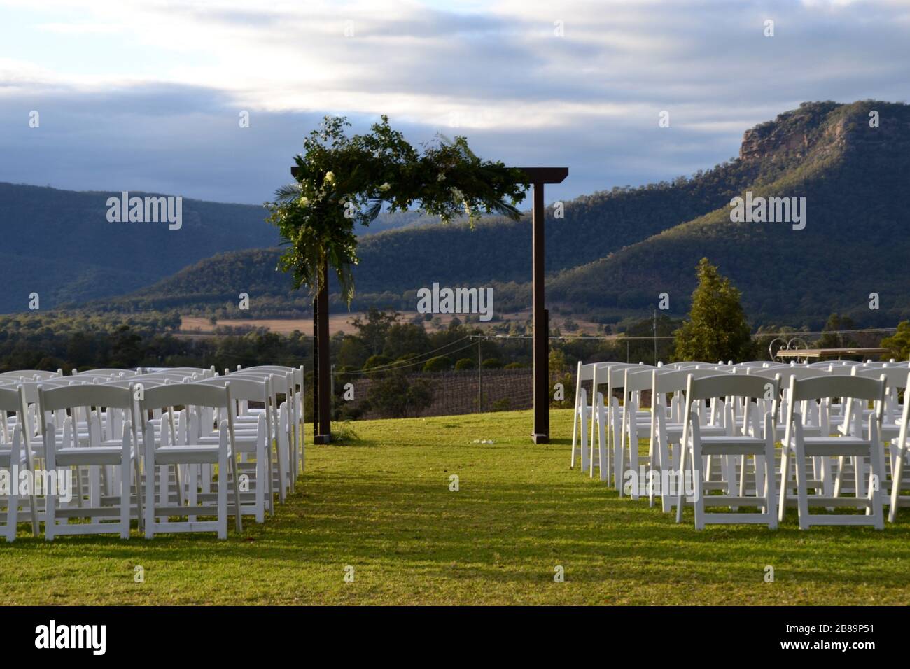 Arco di nozze con file di sedie bianche pronto per una cerimonia che si affaccia sulla Hunter Valley in NSW, Australia Foto Stock