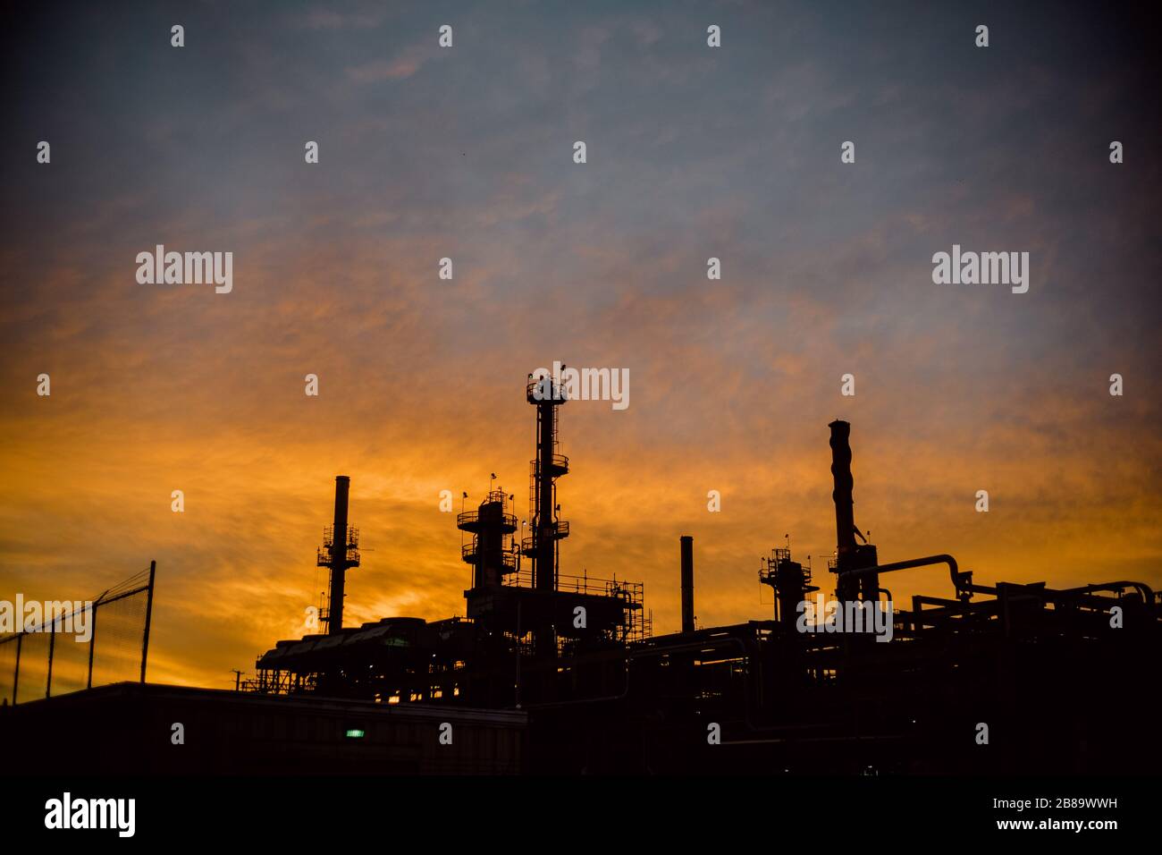 La silhouette di una raffineria di olio durante l'alba. Foto Stock