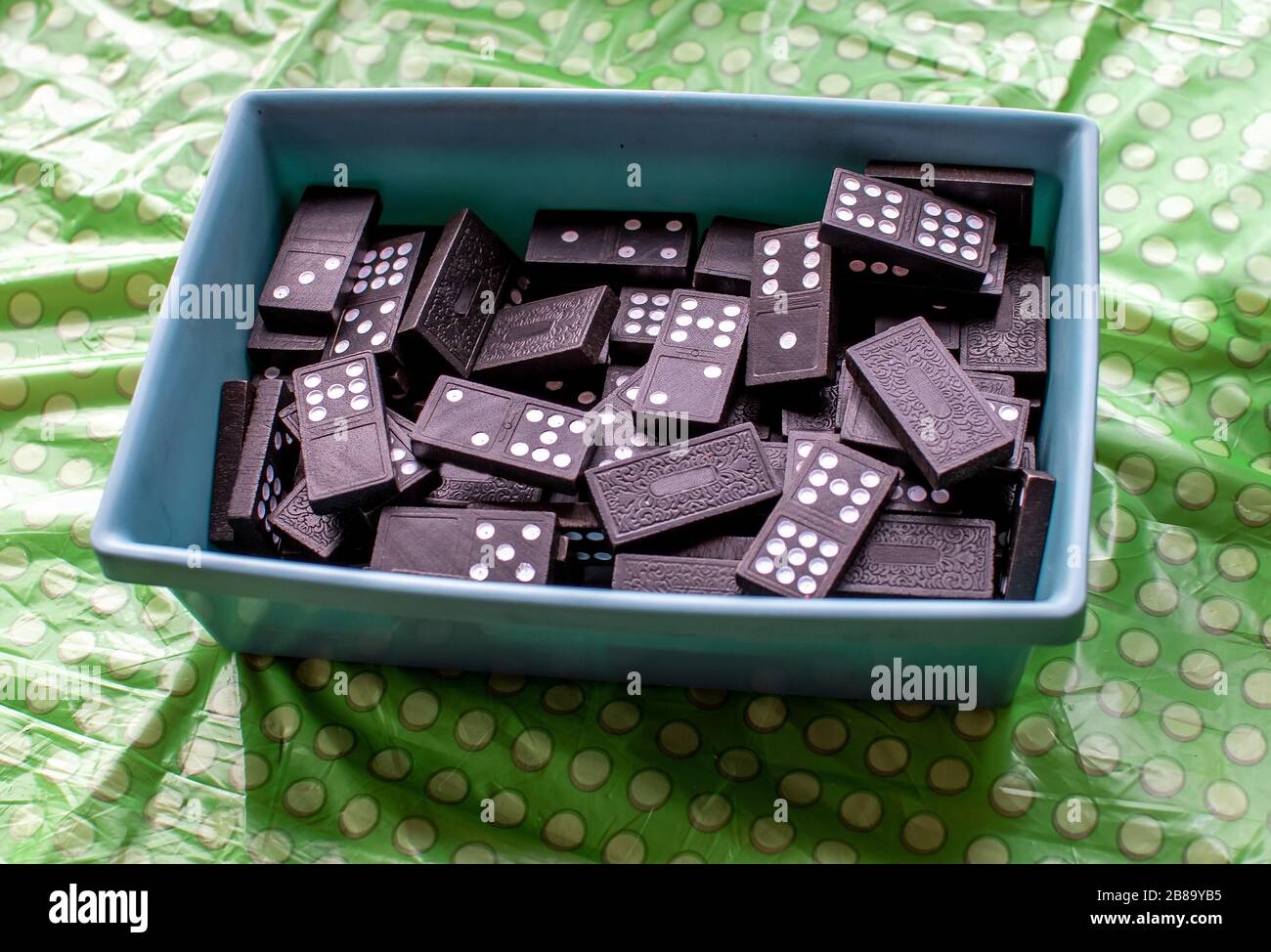 Container di pezzi domino sono pronti per una famiglia a giocare una partita Foto Stock