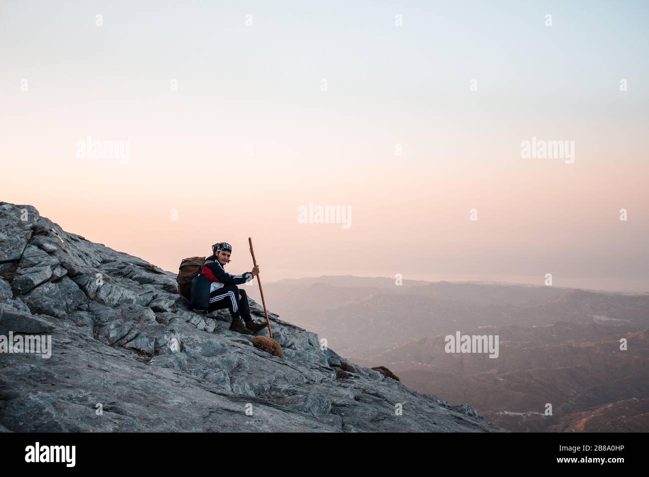 Uomo che fa escursioni in montagna vicino alla scogliera. Foto Stock