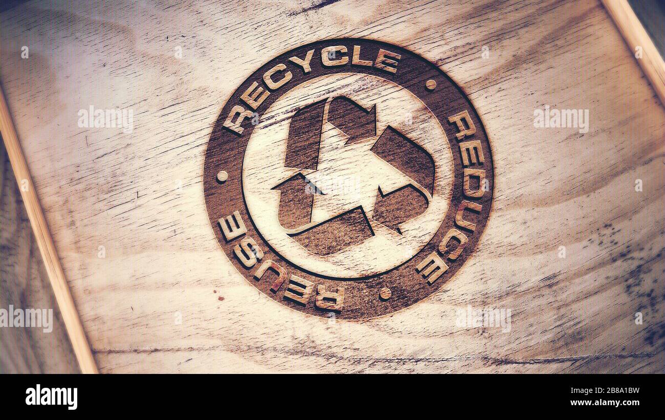 Logo di riciclo inciso su sfondo di legno. Foto Stock