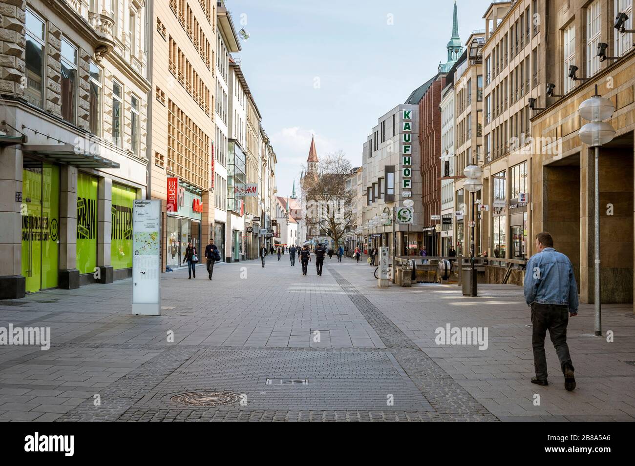 Baviera-Monaco-Germania, 20. März 2020: Poche persone camminano sulla piazza Marienplatz di Monaco, che è di solito affollata, ma rimane vuota a causa del nuovo arredo Foto Stock