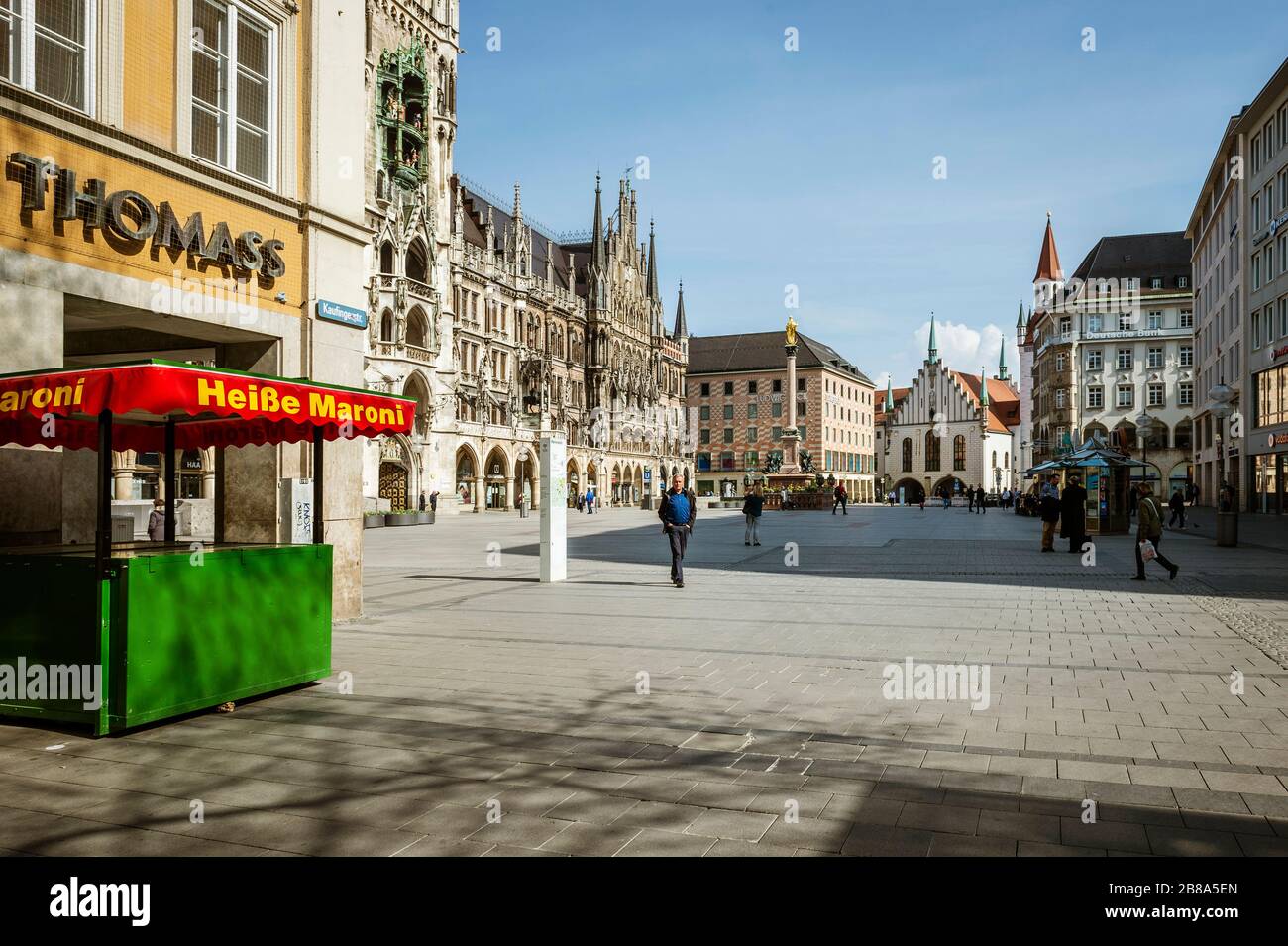 Baviera-Monaco-Germania, 20. März 2020: Poche persone camminano sulla piazza Marienplatz di Monaco, che è di solito affollata, ma rimane vuota a causa del nuovo arredo Foto Stock