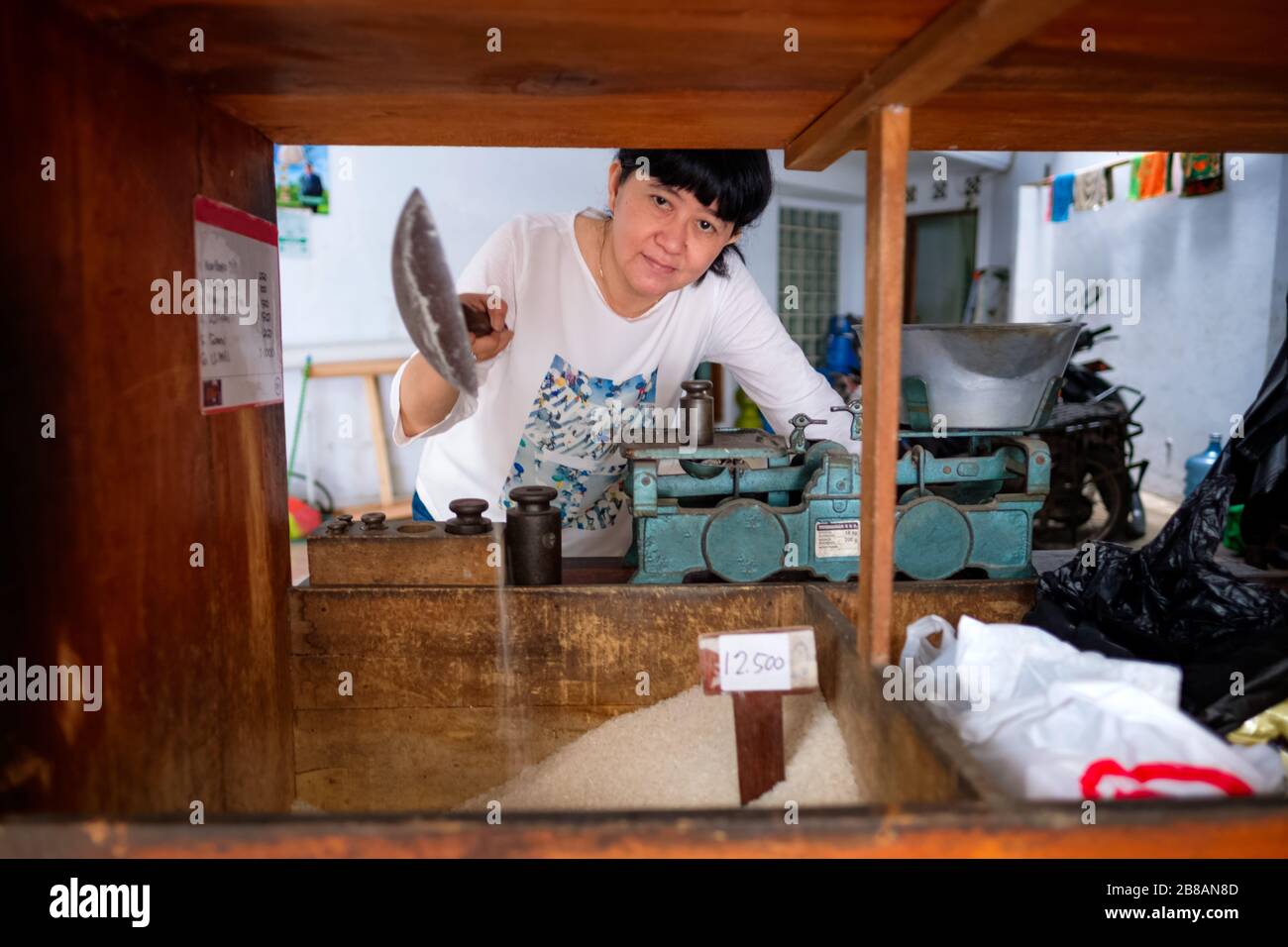 Le donne indonesiane asiatiche che vendono riso all'interno di un piccolo business store locale a conduzione familiare, o localmente chiamato warung. Si trova a Tasikmalaya, Indonesia. Foto Stock