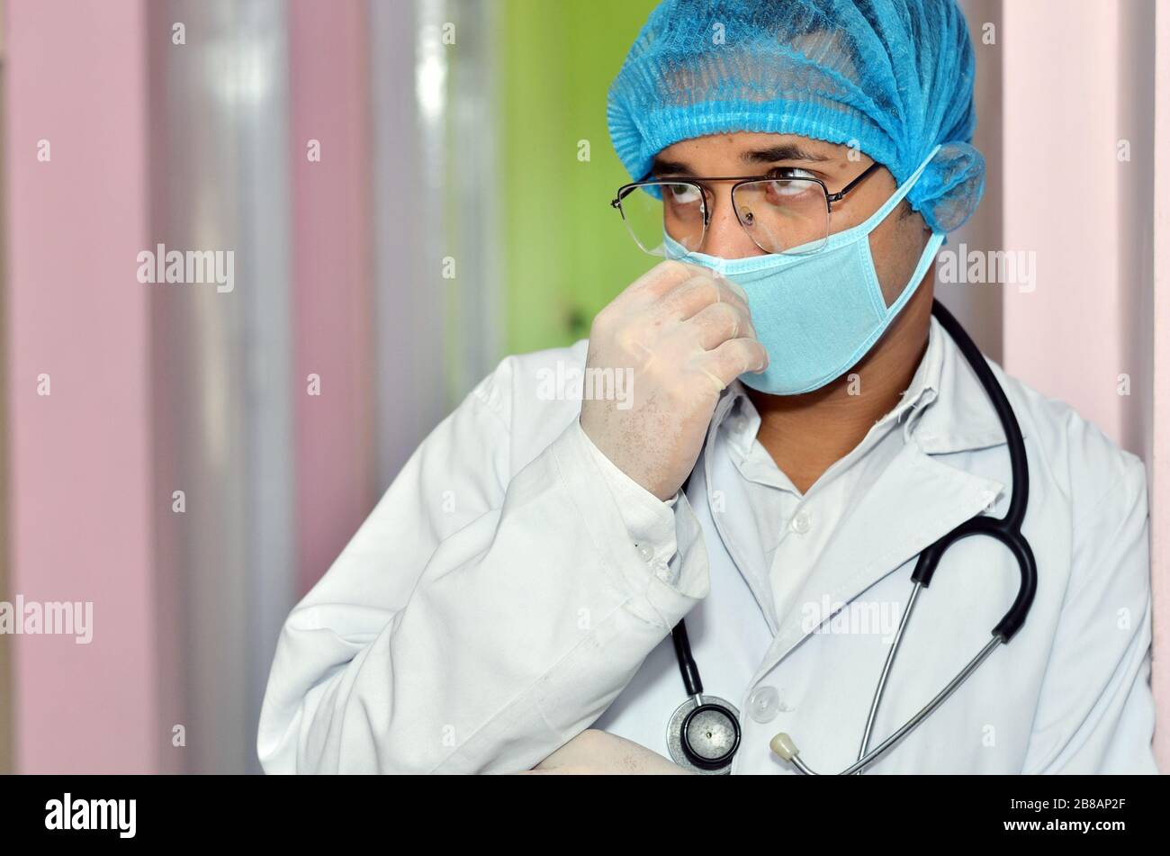 Un medico con stetoscopio e maschera Foto Stock