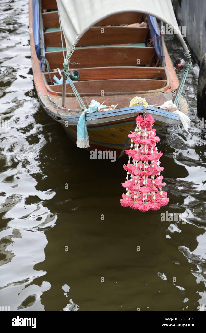 Colpo verticale di una piccola nave di legno con fiori rosa allegato Foto Stock