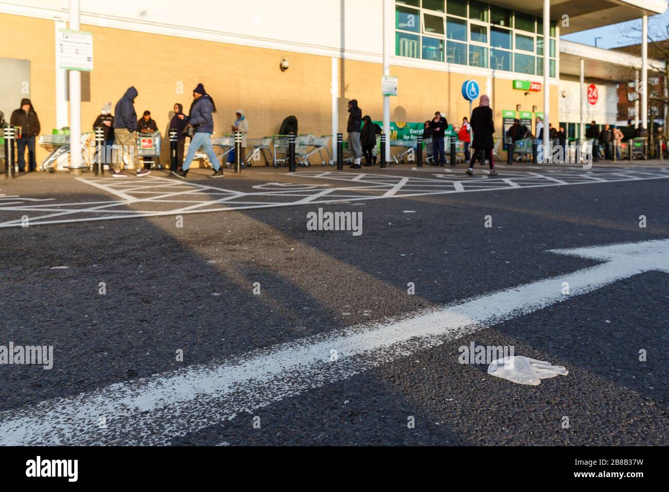 Middlesex, Regno Unito. 21 Mar 2020. Il Regno Unito si adegua a Life Under the Coronavirus Pandemic. Un guanto di gomma scartato nel parcheggio, come la gente pratica sociale a distanza mentre la coda per il supermercato come il globale COVID-19 coronavirus pandemic accelera. Le persone hanno indossato guanti di gomma per proteggersi dal virus. Credit: amanda Rose/Alamy Live News Foto Stock